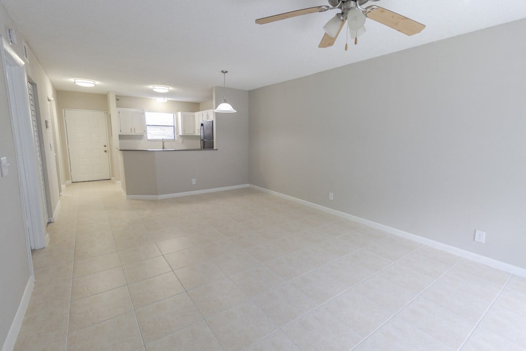 A spacious room with a ceiling fan and tiled flooring.